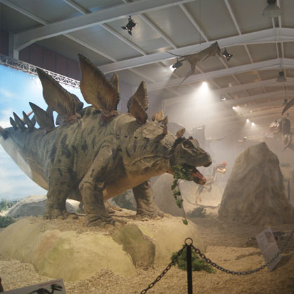 Esposizione dei Dinosauri lo Stegosaurus immerso nella scenografia che riproduce il suo ambiente